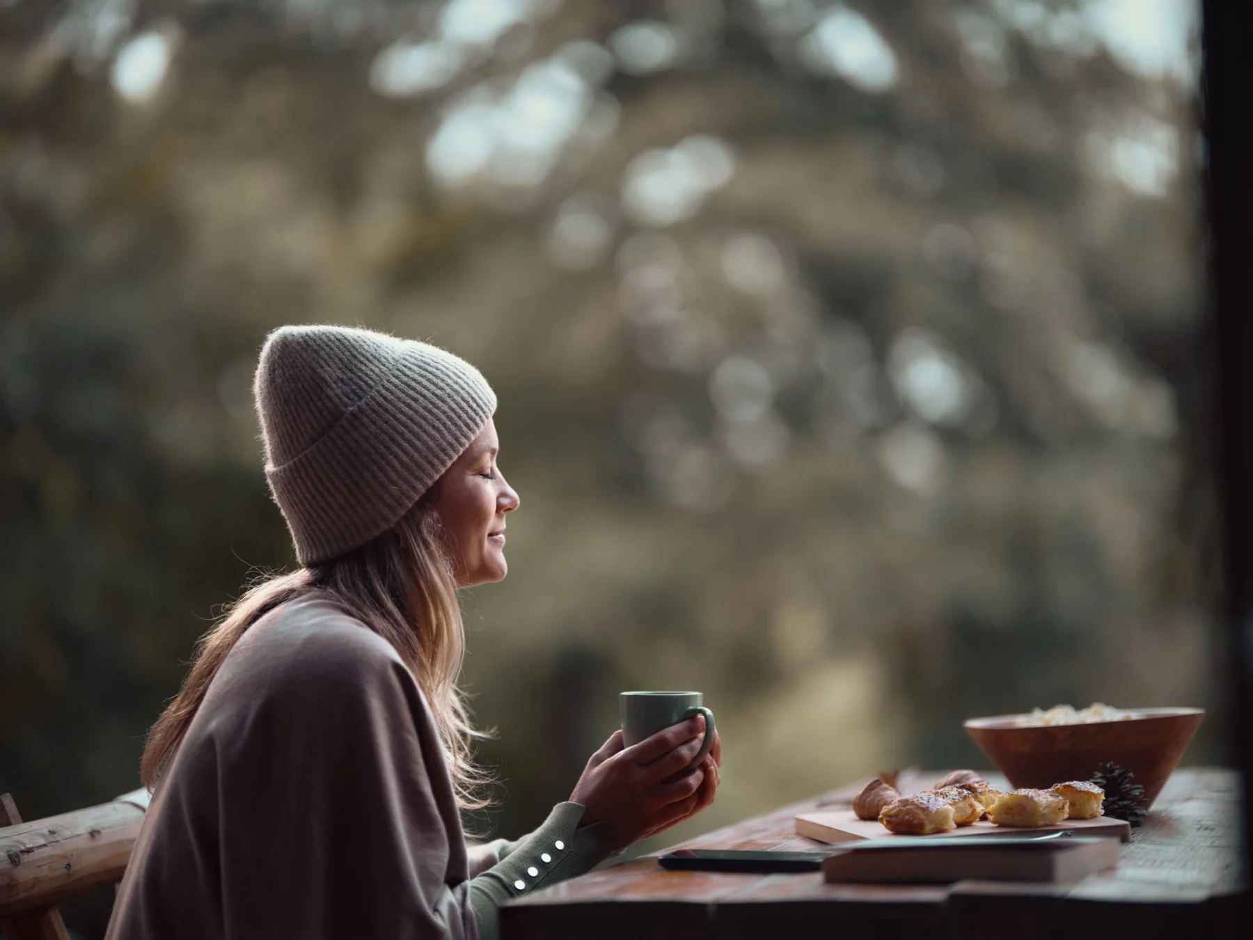 Smiling woman enjoying in coffee on a patio.