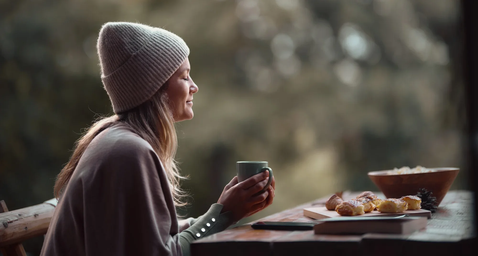 Smiling woman enjoying in coffee on a patio.