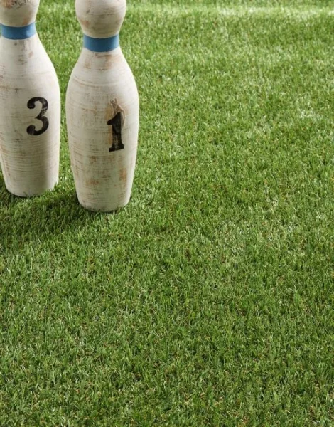 Bowling pins placed on artificial grass.